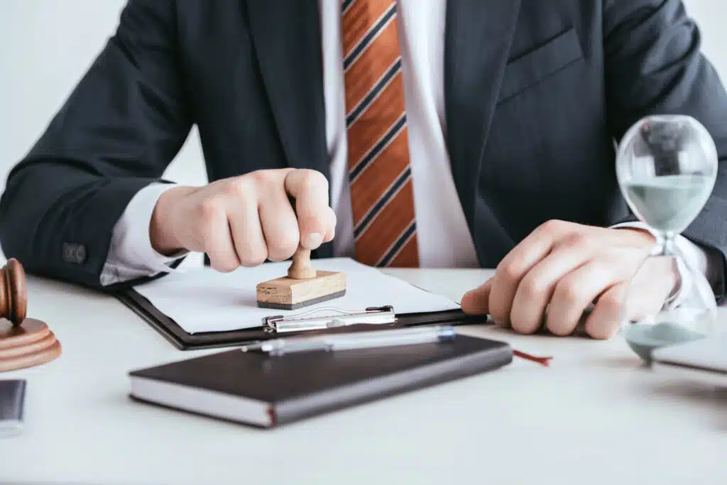 cropped view of man in suit putting stamp on document