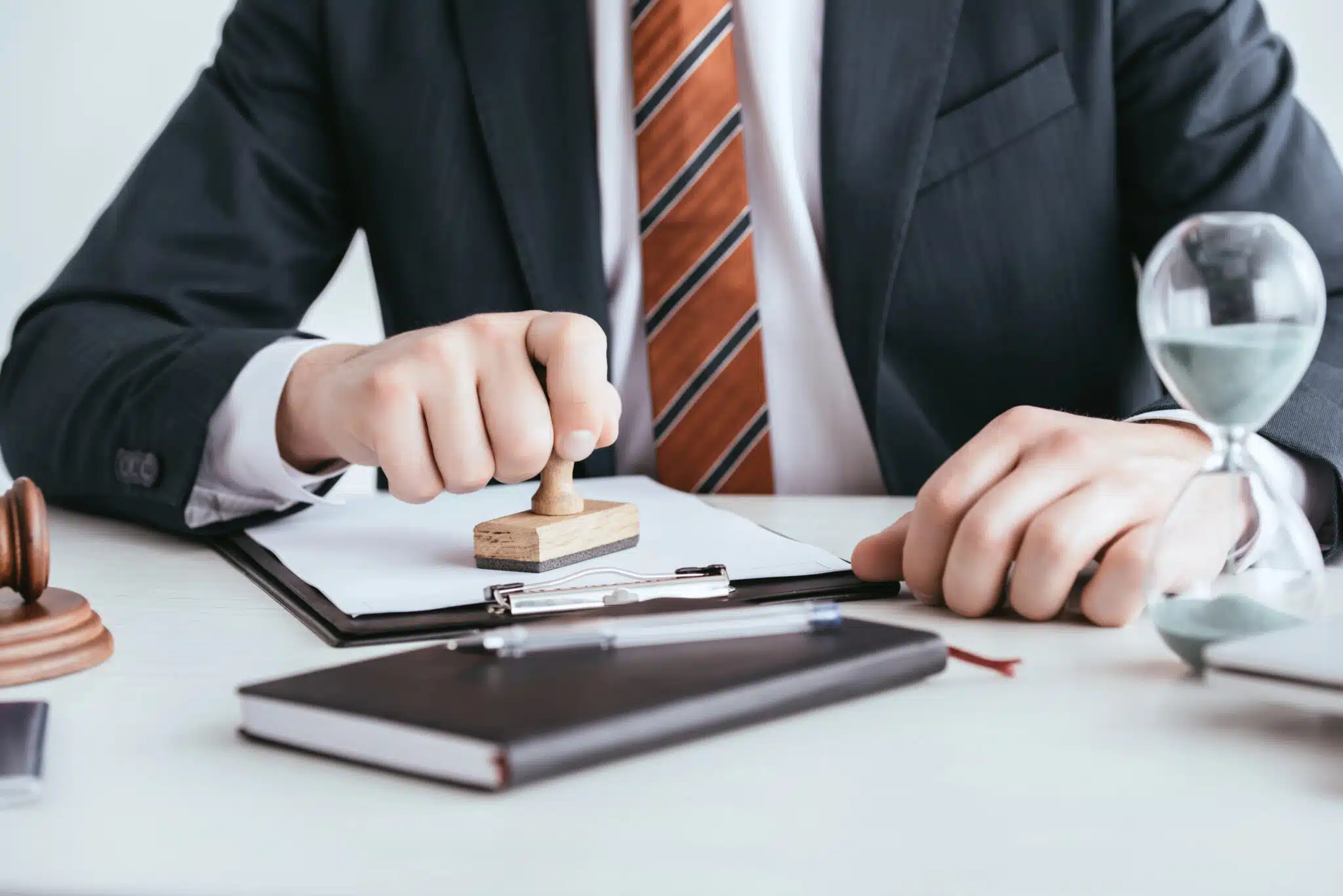 cropped view of man in suit putting stamp on document